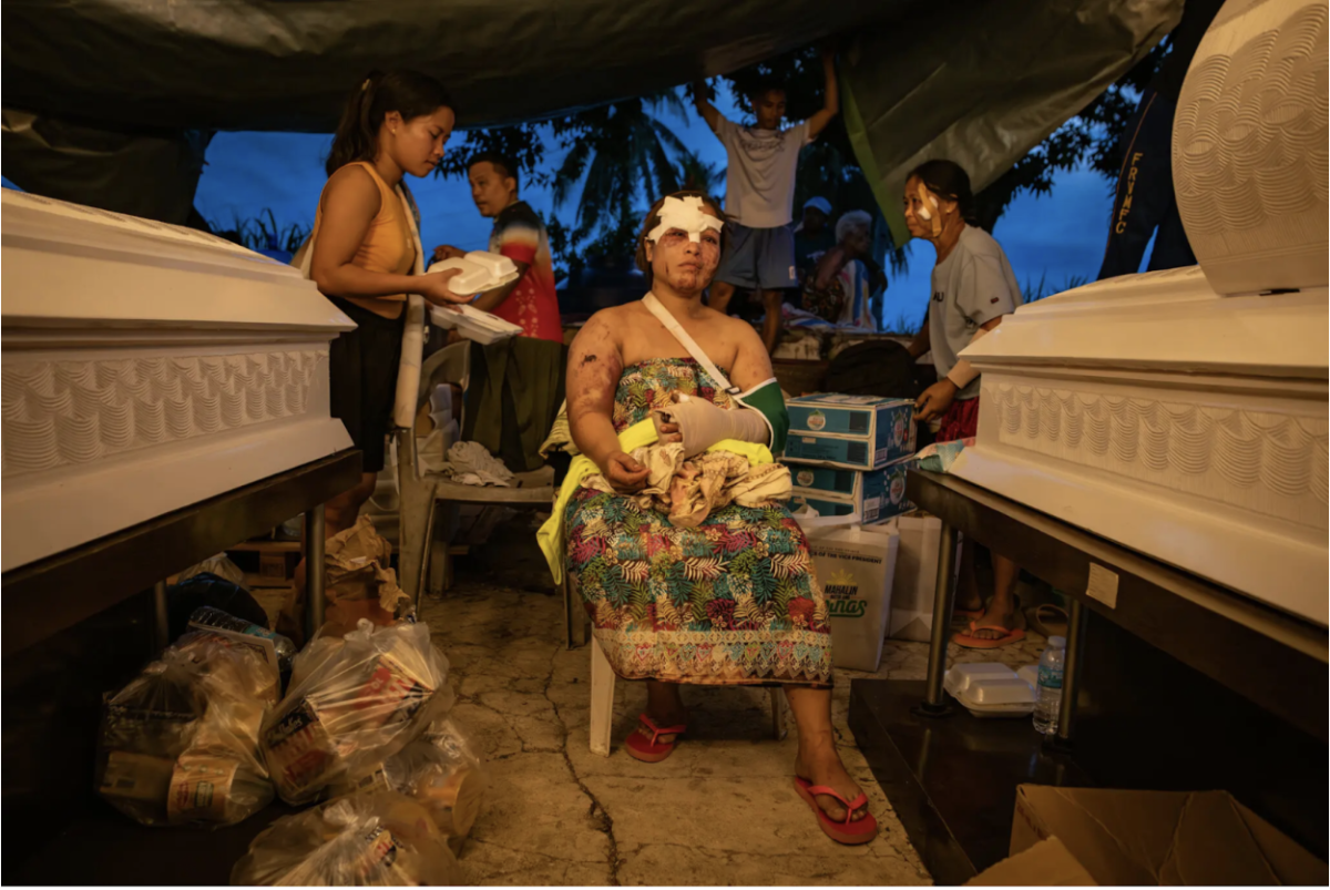A resident with the coffins of her two sons, who were killed due to the earthquake.